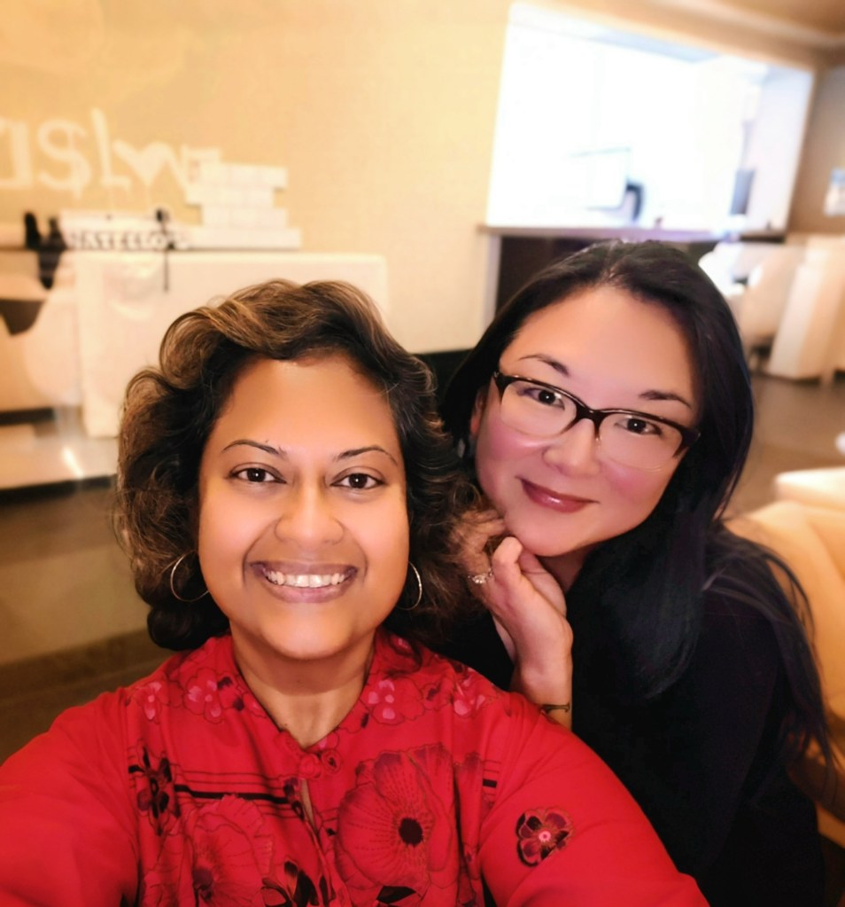 Two Asian-appearing, women- Marielle and Dani, who are counselors at therapyathens, posing and smiling.